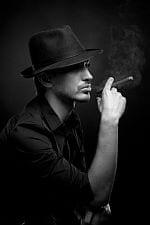 Tajemniczy mężczyzna palący cygaro w kapeluszu