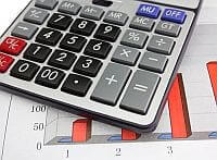 Kalkulator położony na wykresie z grubymi czerwonymi słupkami