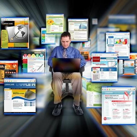 Zadowolony mężczyzna z laptopem na kolanach siedzi w otoczeniu kolorowych okienek internetowych