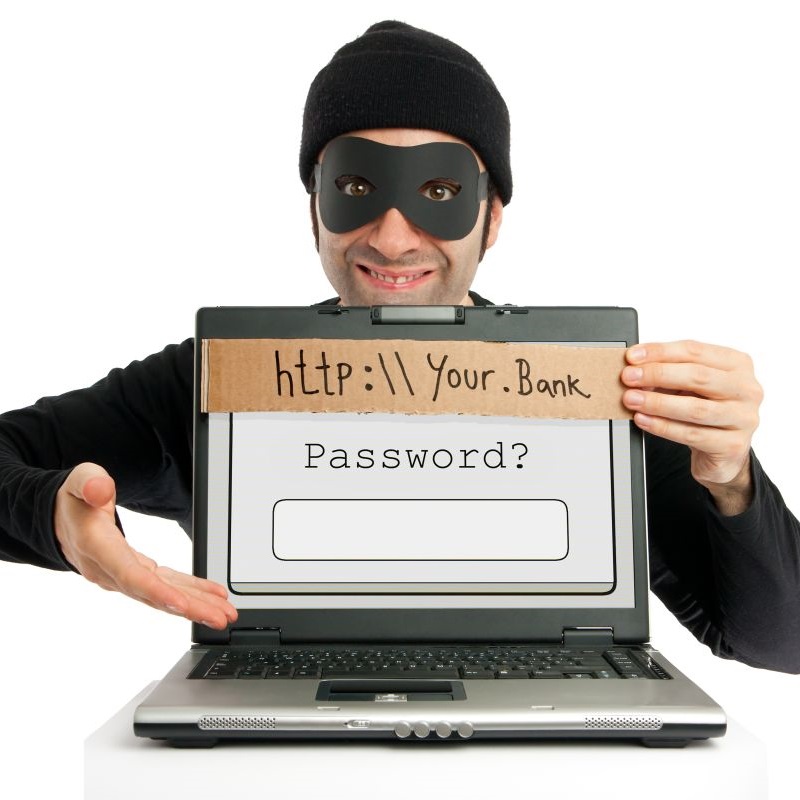 Zamaskowany mężczyzna prezentuje przed sobą laptopa z polem do wpisania hasła