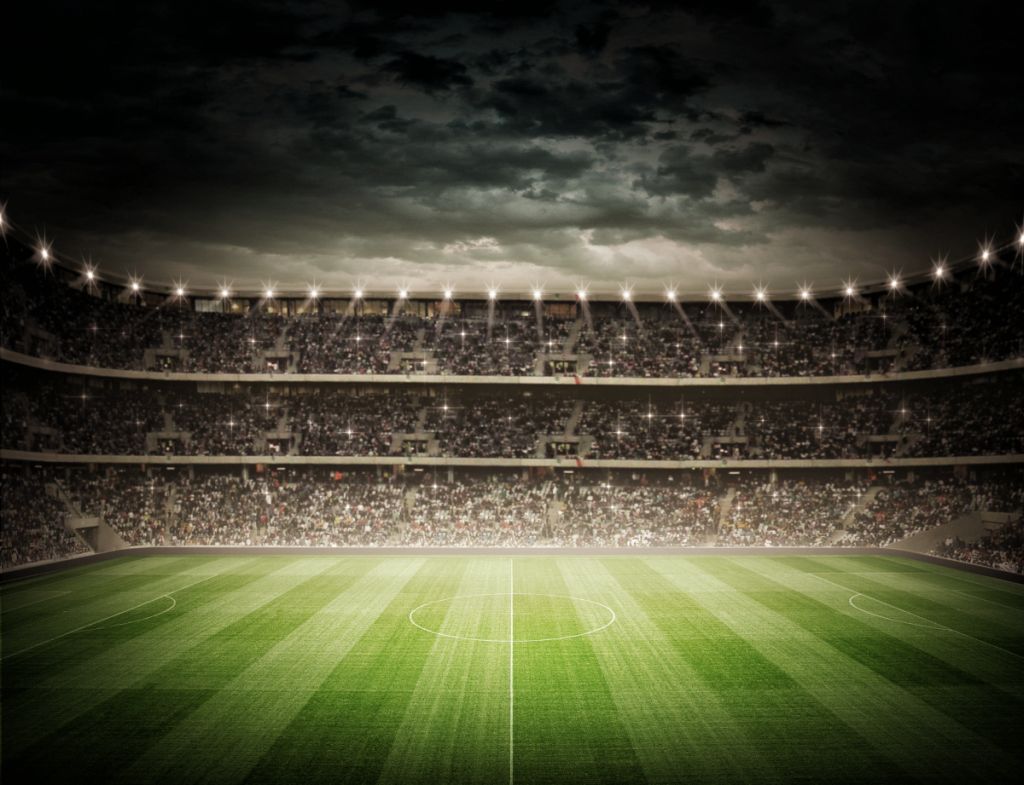 Pusty stadion piłkarski z kibicami pod zachmurzonym niebem