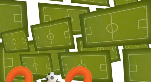 Symbole boisk tworzą w tle dwie zielone ściany łączące się po lewej stronie a na dole podpis pomarańczowych cyfr 2:2 z piłkami zamiast dwukropków