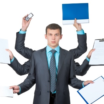Młody mężczyzna w garniturze z sześcioma rękami trzyma elementy biurowe