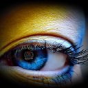 Zbliżenie niebieskiego oka z żółto niebieskim makijarzem